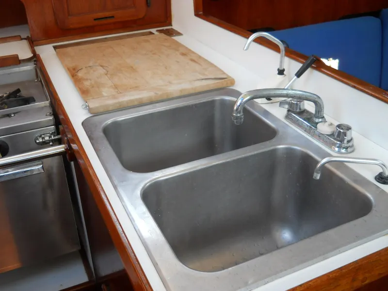 Slide: The Image of Double sink in a 1979 Morgan 382 yacht kitchen with wooden accents and cutting board. - 9