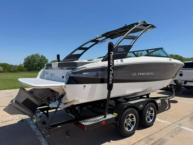 Slide: The Image of 2025 Regal LS2 Surf boat on trailer, sleek design, parked outdoors under clear blue sky. - 10