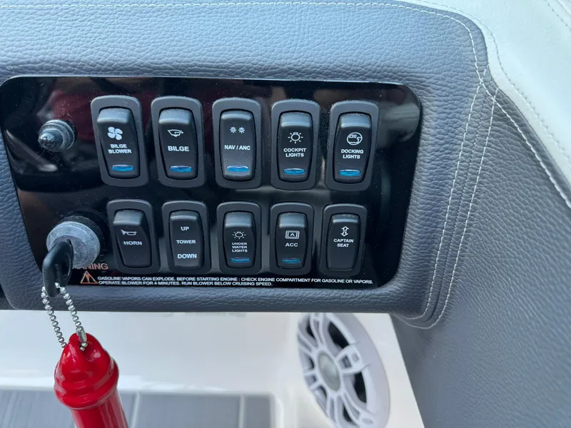 Slide: The Image of Control panel of 2025 Regal LS2 Surf boat with various switches and keychain. - 30