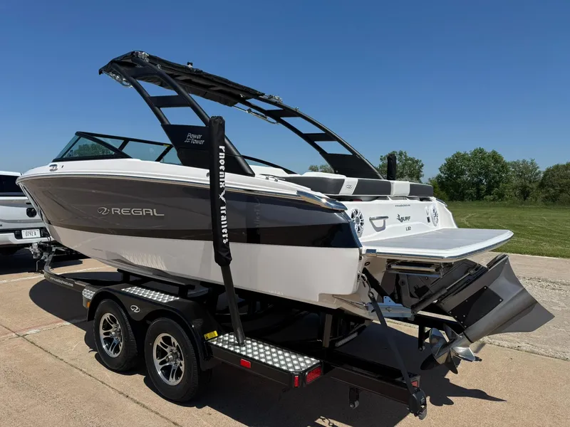 Slide: The Image of 2025 Regal LS2 Surf boat on trailer, sleek design, sunny day, outdoor setting. - 6