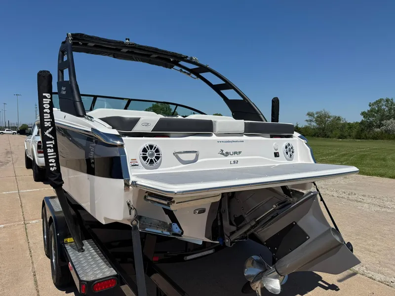 Slide: The Image of 2025 Regal LS2 Surf boat on trailer, rear view, sunny day. - 7