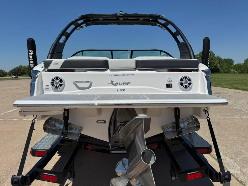 Slide: The Image of 2025 Regal LS2 Surf boat rear view on trailer, showcasing propeller and swim platform. - 8