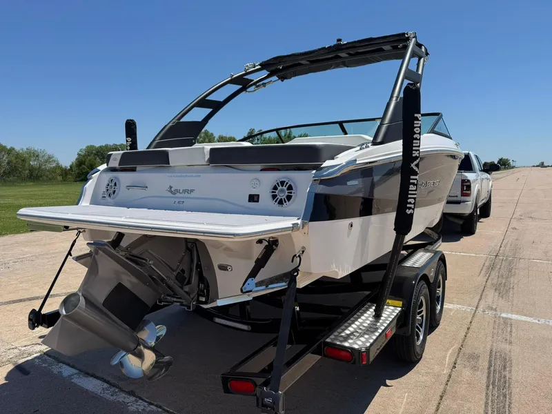 Slide: The Image of 2025 Regal LS2 Surf boat on trailer, parked on a sunny road. - 9