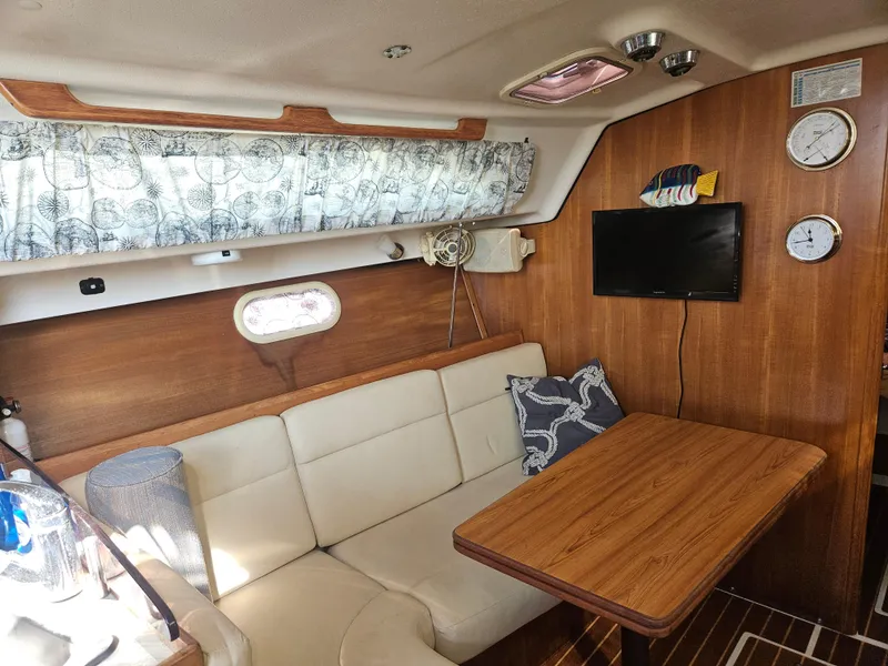 Slide: The Image of Cozy interior of 2006 Catalina 309 sailboat with wood paneling and seating area. - 7