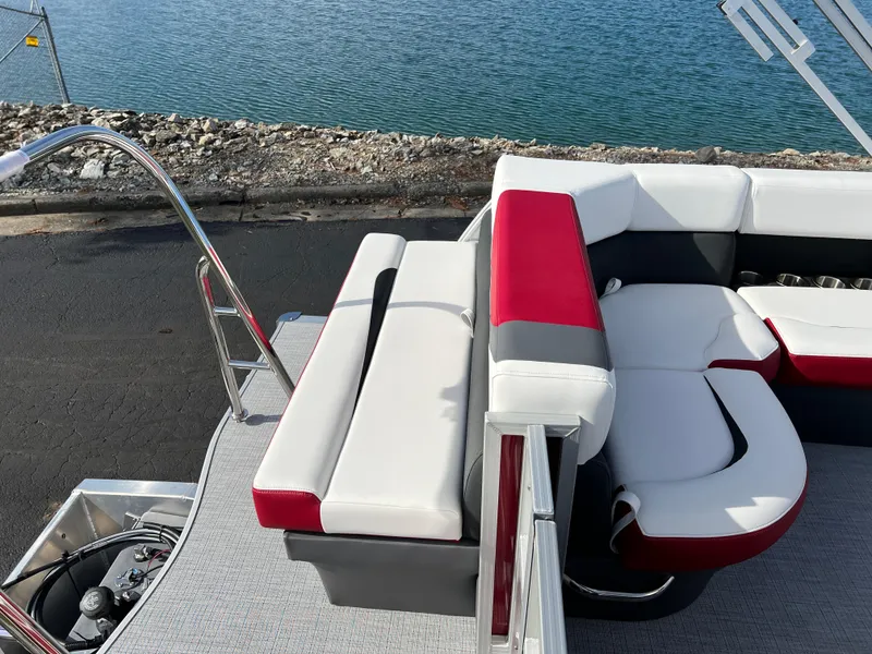 Slide: The Image of 2025 South Bay S 220 CR2 boat interior with red and white seating by the water. - 16