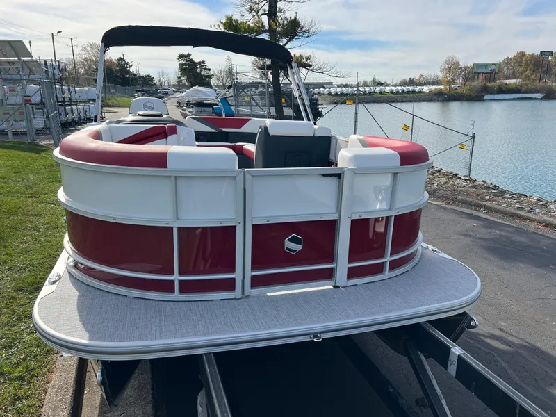 Slide: The Image of 2025 South Bay S 220 CR2 pontoon boat docked by a serene lakeside. - 2