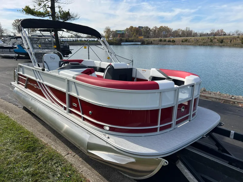 Slide: The Image of 2025 South Bay S 220 CR2 pontoon boat docked by a serene lake. - 3