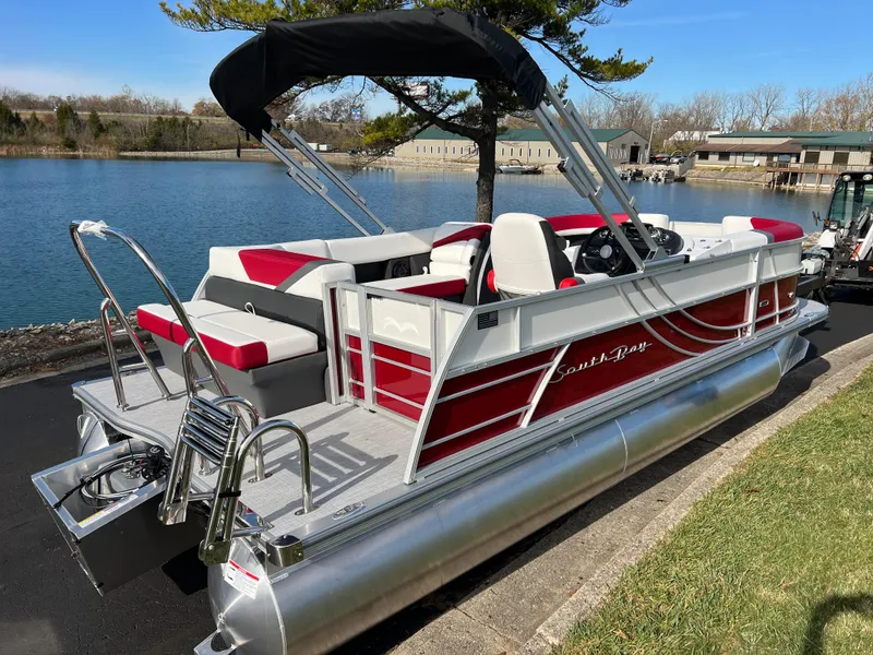 Slide: The Image of 2025 South Bay S 220 CR2 pontoon boat docked by a serene lake. - 4
