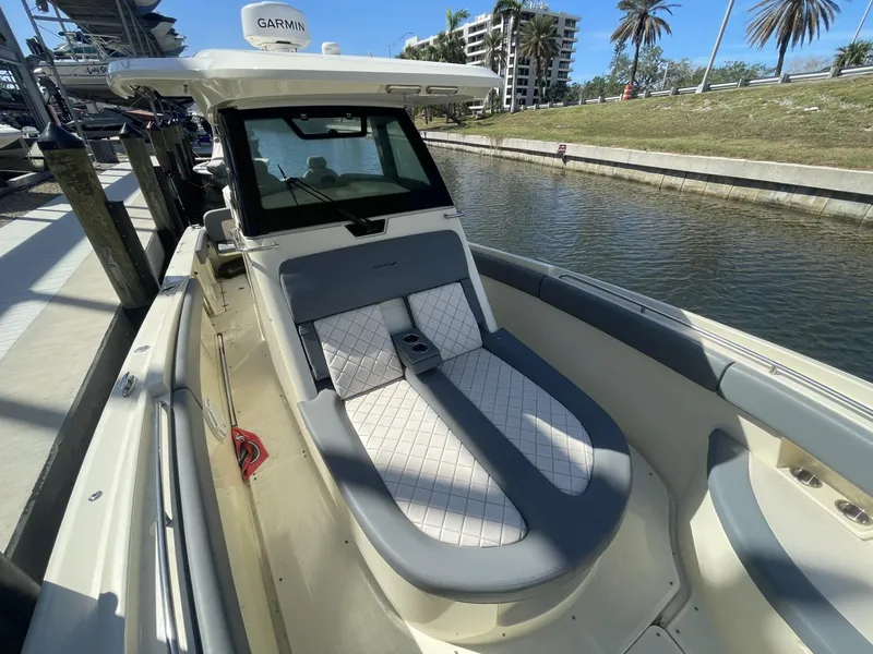 Slide: The Image of 2021 Chris-Craft Catalina 30 boat with cushioned seating, docked by a canal. - 10