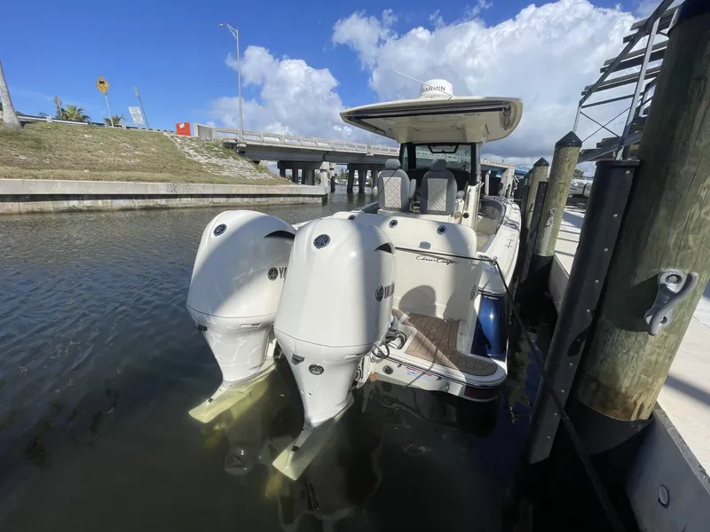 Slide: The Image of 2021 Chris-Craft Catalina 30 docked with dual outboard engines under a clear sky. - 2