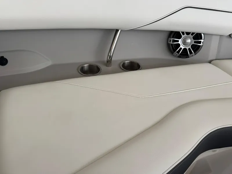 Slide: The Image of 2025 Regal LS4 Surf boat interior with beige seating, cup holders, and speaker. - 30