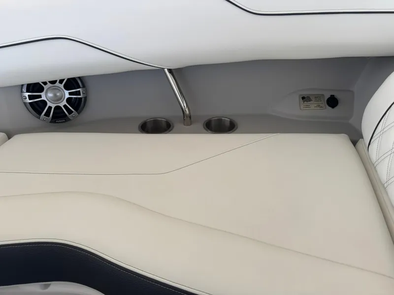 Slide: The Image of 2025 Regal LS4 Surf boat interior with speaker, cup holders, and white seating. - 31