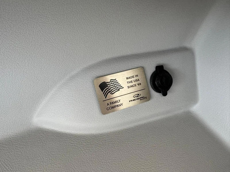 Slide: The Image of 2025 Regal LS4 Surf boat interior with "Made in the USA" plaque and company logo. - 32