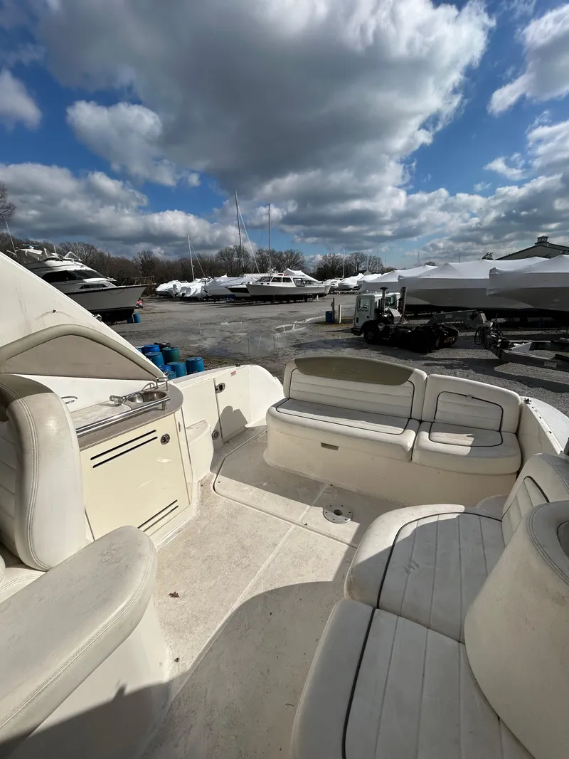 Slide: The Image of 2006 Sea Ray 290 Sundancer boat interior with seating, under a cloudy sky. - 3