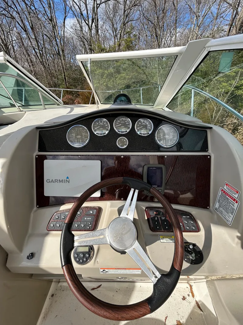 Slide: The Image of 2006 Sea Ray 290 Sundancer dashboard with Garmin navigation system and wood-trimmed steering wheel. - 4