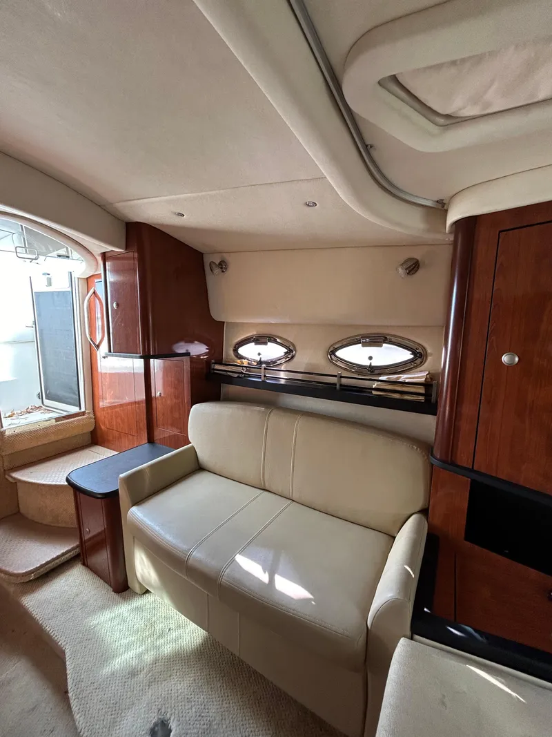Slide: The Image of Interior of 2006 Sea Ray 290 Sundancer with beige seating and wooden cabinetry. - 6