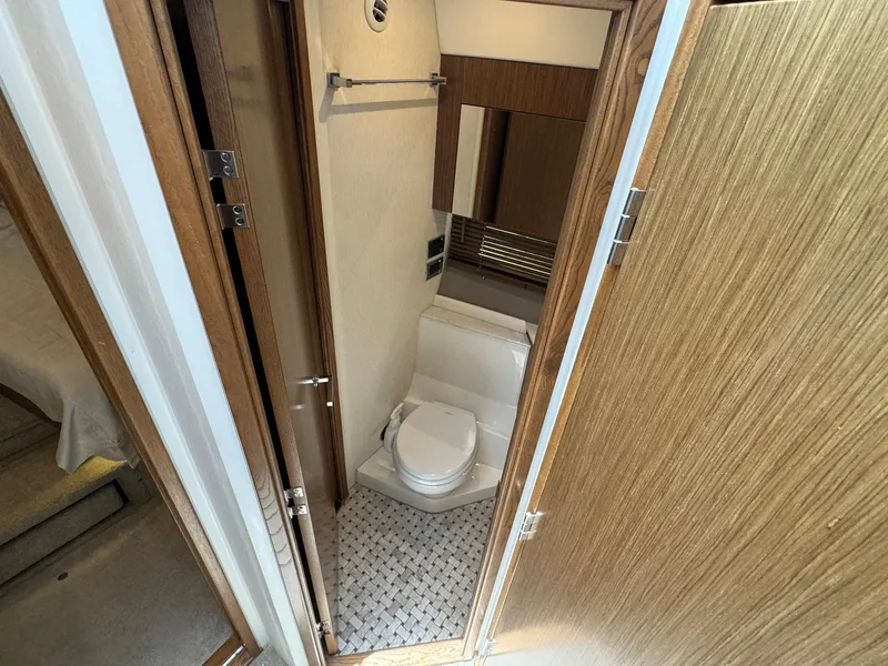 Slide: The Image of 2017 Sea Ray Sundancer 460 bathroom with modern fixtures and wood accents. - 26