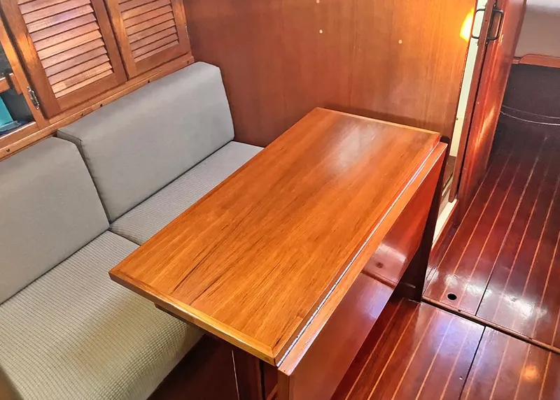 Slide: The Image of 1983 Freedom Cat Ketch interior with wooden table and cushioned seating. - 13