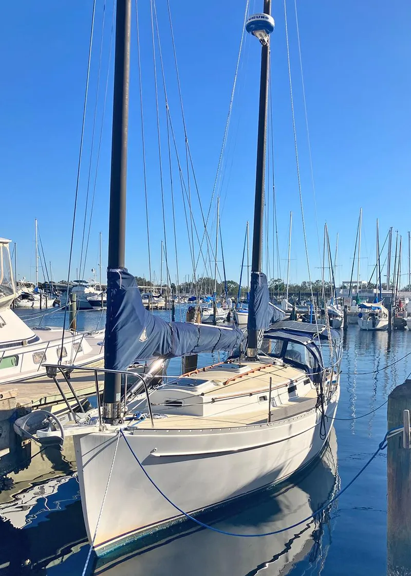 Slide: The Image of 1983 Freedom Cat Ketch sailboat docked in a marina under clear blue skies. - 2