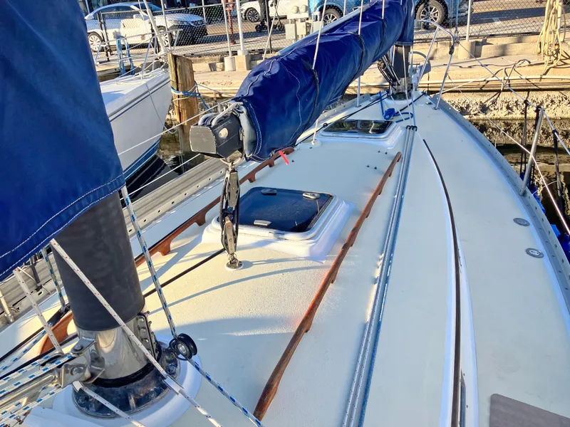 Slide: The Image of 1983 Freedom Cat Ketch sailboat deck with blue sail cover, docked at marina. - 4