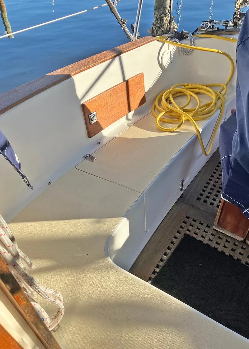 Slide: The Image of 1983 Freedom Cat Ketch sailboat cockpit with yellow hose and wooden accents. - 8