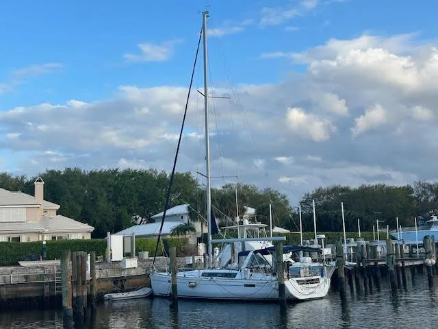 Slide: The Image of 2016 Beneteau Oceanis 45 sailboat docked at a marina under a cloudy sky. - 3