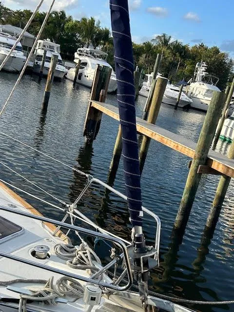 Slide: The Image of 2016 Beneteau Oceanis 45 sailboat docked at a marina under a blue sky. - 32