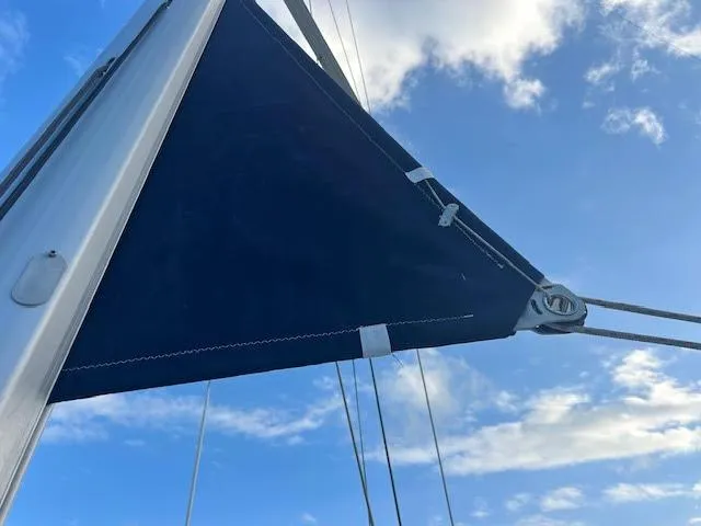 Slide: The Image of Beneteau Oceanis 45 sailboat docked, 2016 model, with visible anchor and calm water reflection. - 36