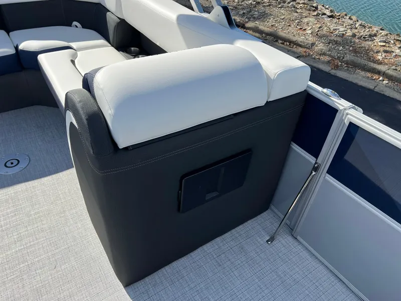 Slide: The Image of 2025 South Bay S 220CR2 boat interior with white and black seating by the water. - 13