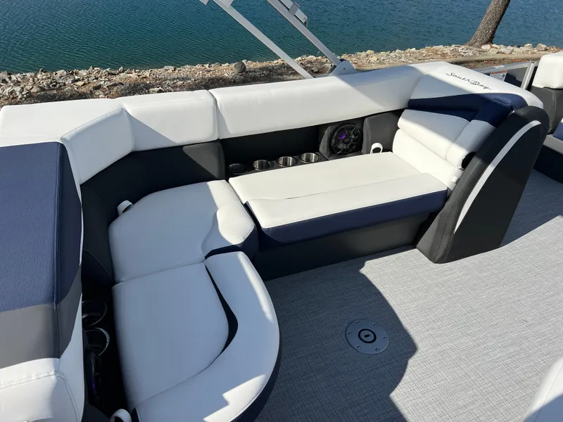 Slide: The Image of 2025 South Bay S 220CR2 boat interior with white and gray seating by the water. - 19