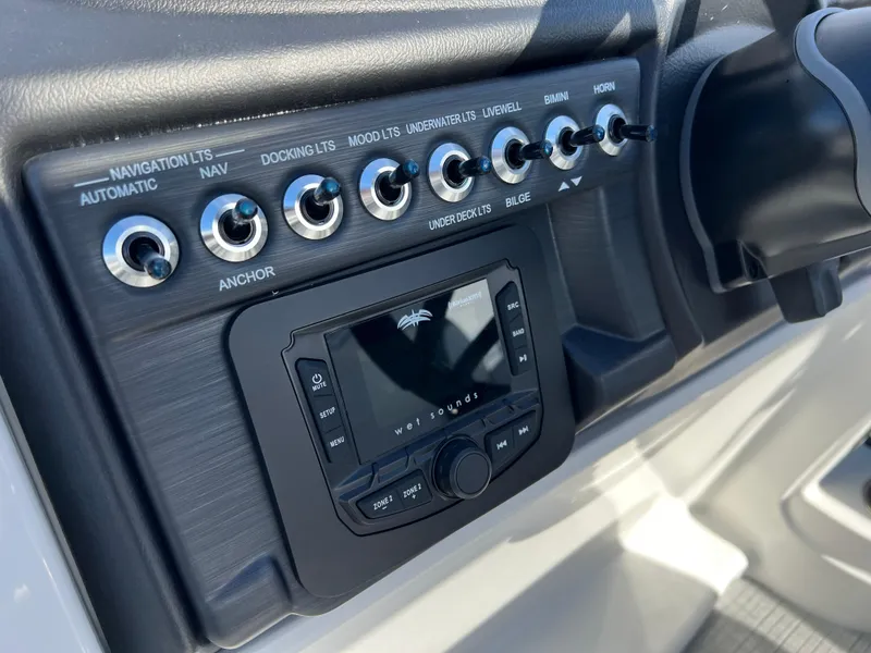 Slide: The Image of Control panel of 2025 South Bay S 220CR2 boat with various switches and display. - 23