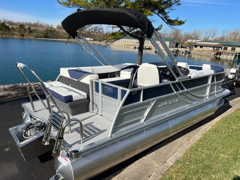Slide: The Image of 2025 South Bay S 220CR2 pontoon boat docked by a serene lake. - 5