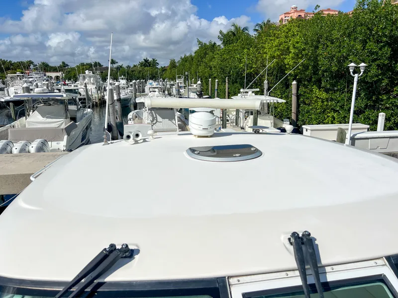 Slide: The Image of 2008 Tiara Yachts 3900 Sovran docked in a marina, surrounded by lush greenery. - 18