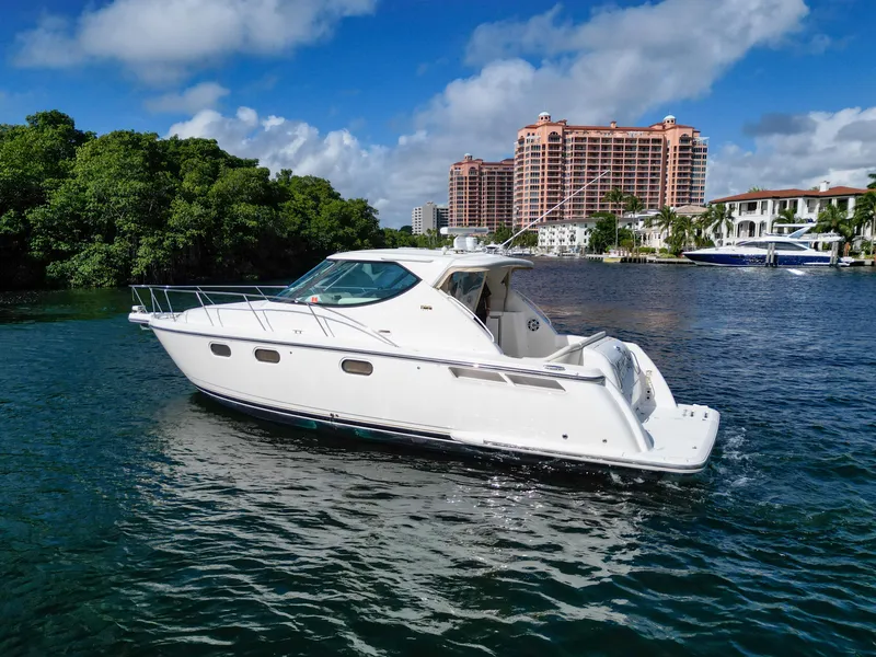 Slide: The Image of 2008 Tiara Yachts 3900 Sovran cruising on a scenic waterway with buildings in the background. - 2