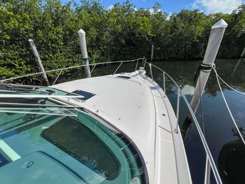 Slide: The Image of 2008 Tiara Yachts 3900 Sovran docked near lush greenery. - 23