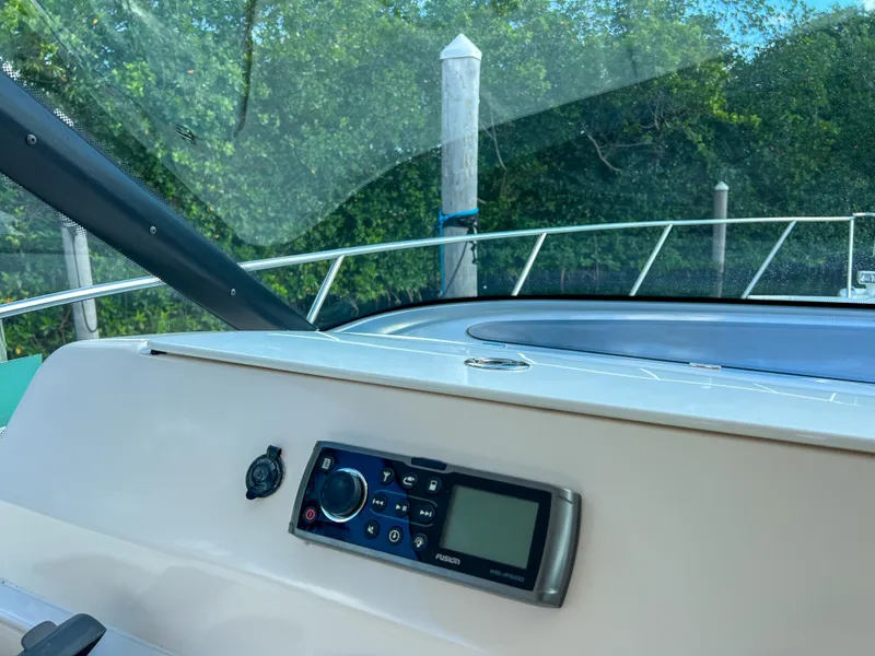 Slide: The Image of 2008 Tiara Yachts 3900 Sovran dashboard with control panel, docked near lush greenery. - 35