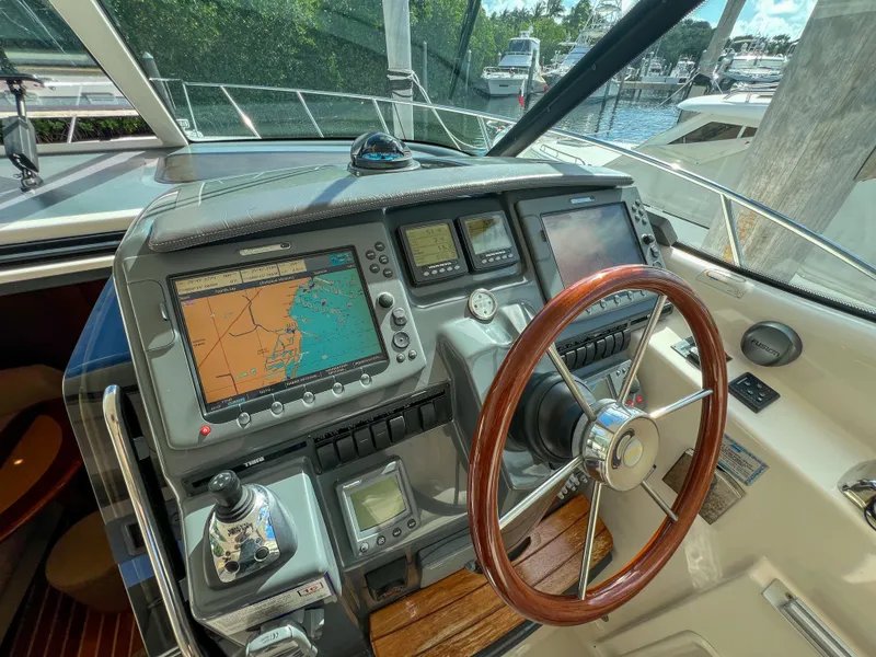 Slide: The Image of 2008 Tiara Yachts 3900 Sovran helm with navigation screens and wooden steering wheel. - 42