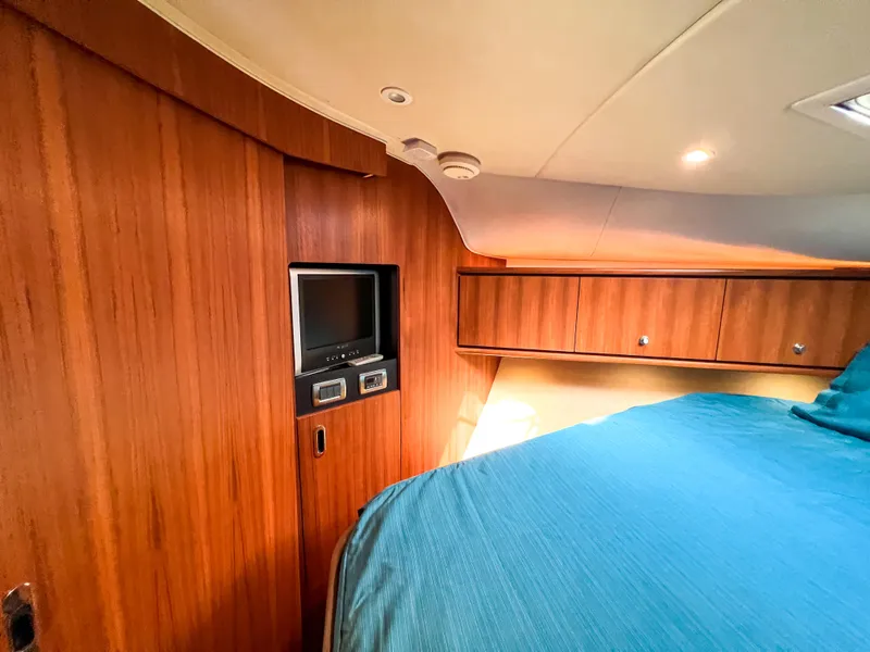 Slide: The Image of 2008 Tiara Yachts 3900 Sovran cabin with wood paneling and cozy bed. - 47