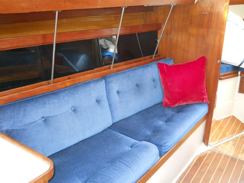 Slide: The Image of Blue cushioned seating with red pillow in 1987 Catalina C-34 sailboat interior. - 13