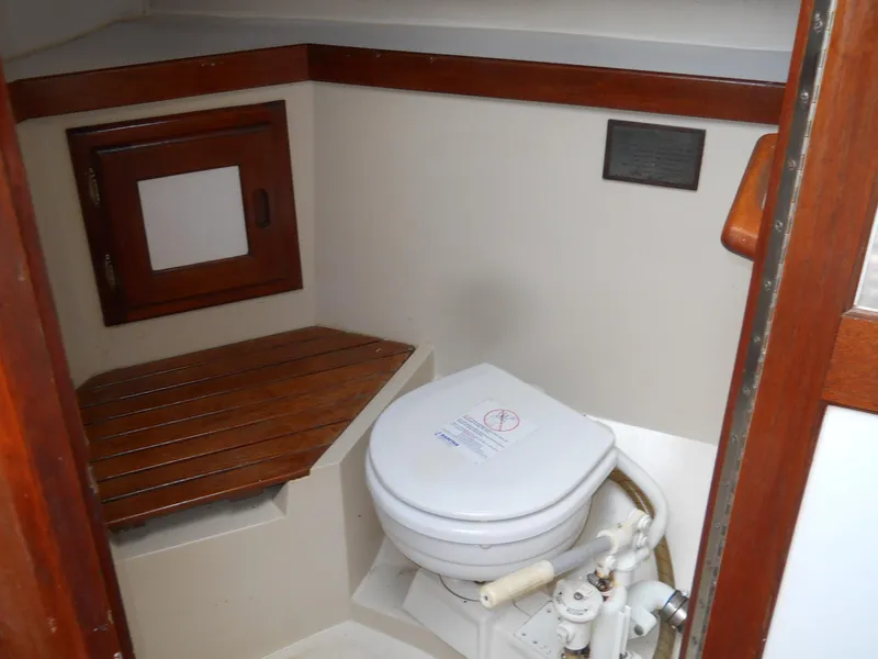 Slide: The Image of 1987 Catalina C-34 boat bathroom with wooden accents and compact toilet. - 16