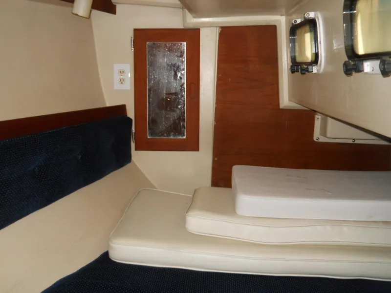 Slide: The Image of Interior cabin of a 1987 Catalina C-34 sailboat with cushions and wooden paneling. - 19