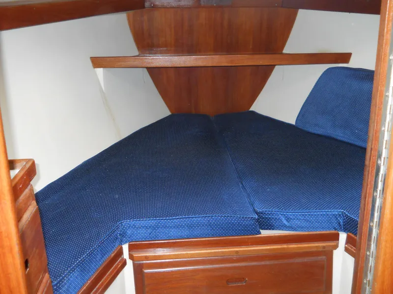 Slide: The Image of 1987 Catalina C-34 boat cabin with blue cushions and wooden interior. - 20