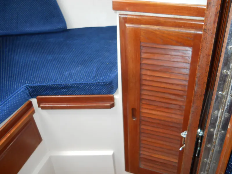 Slide: The Image of Interior of 1987 Catalina C-34 sailboat with blue cushion and wooden cabinet. - 21