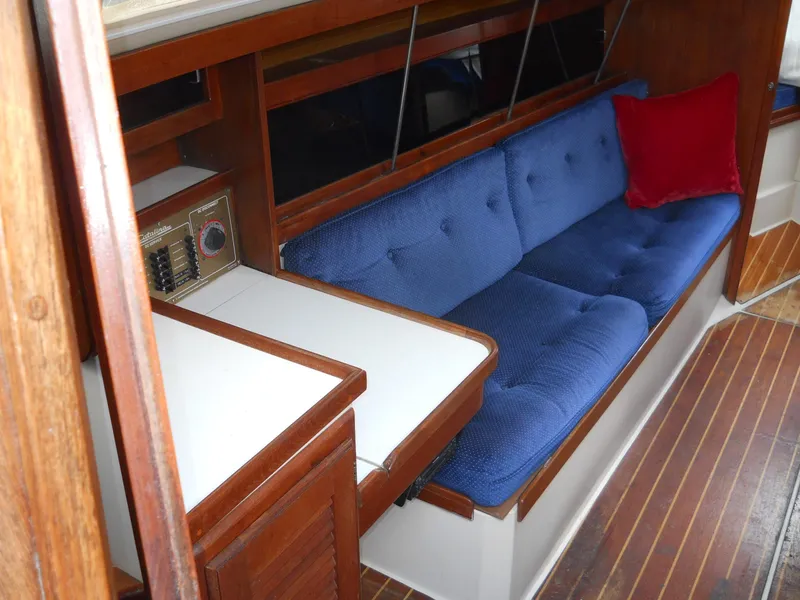 Slide: The Image of Interior of 1987 Catalina C-34 sailboat with blue cushioned seating and wooden accents. - 7