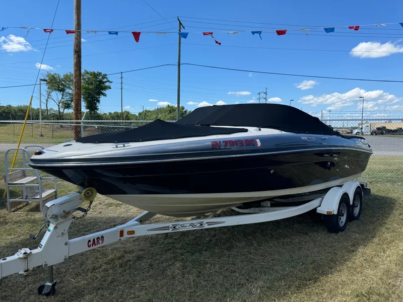 Slide: The Image of 2006 Sea Ray 205 Sport boat on trailer, covered, outdoors under blue sky. - 0