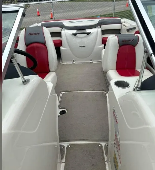 Slide: The Image of 2006 Sea Ray 205 Sport boat interior with red and white seating, steering wheel, and cup holder. - 2