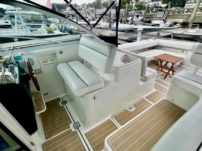 Slide: The Image of 2001 Tiara Yachts 2900 Coronet interior with white seating and wooden accents at a marina. - 11