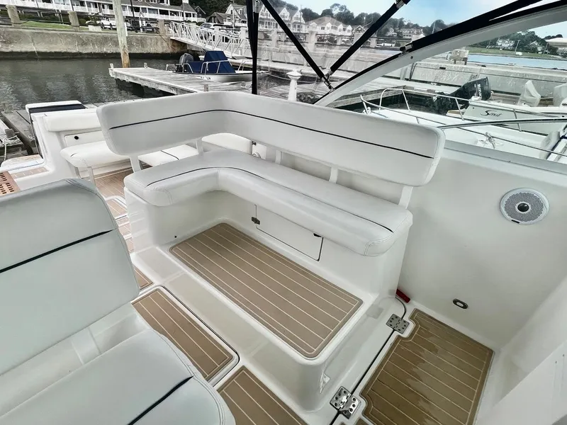 Slide: The Image of 2001 Tiara Yachts 2900 Coronet with white seating and wood-accented deck at a marina. - 12