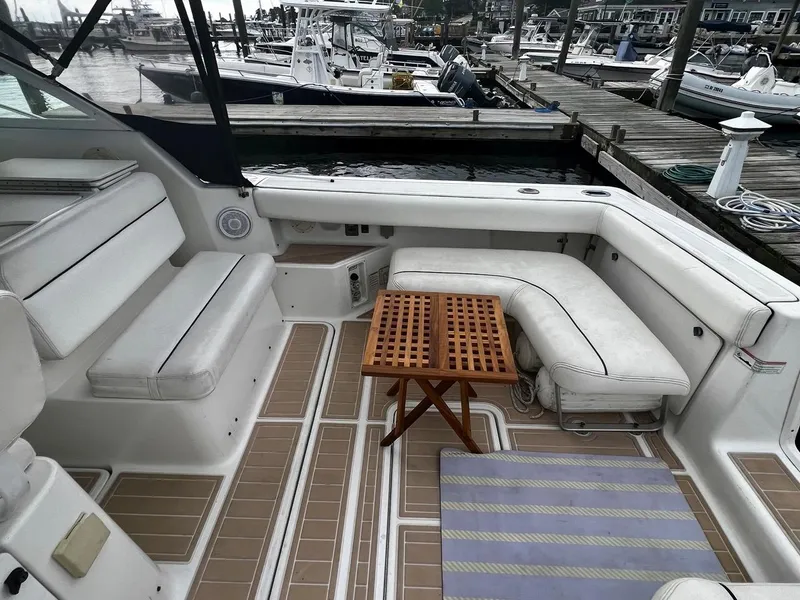 Slide: The Image of 2001 Tiara Yachts 2900 Coronet interior with white seating and wooden table at dock. - 14