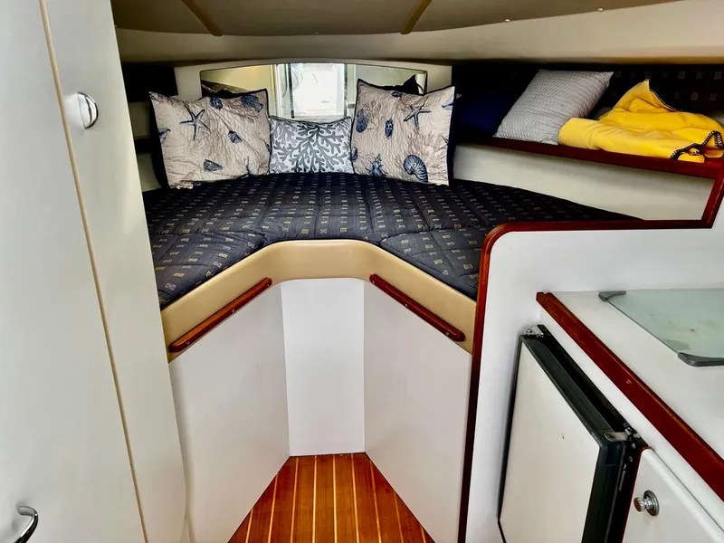 Slide: The Image of 2001 Tiara Yachts 2900 Coronet cabin interior with cozy bedding and wooden flooring. - 17